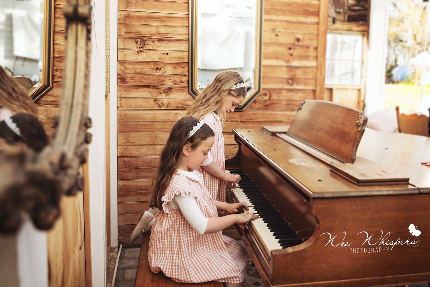 two girls are playing piano and the photograph is taken by wee whispers