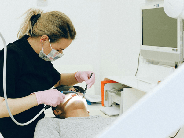 Lady dentist is operating a dental patient