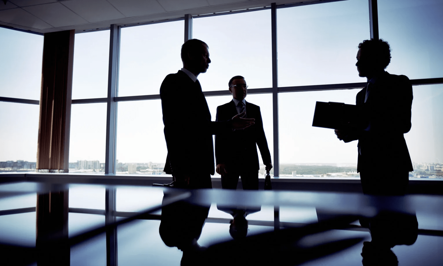 3 persons are standing in M&A Advisory office