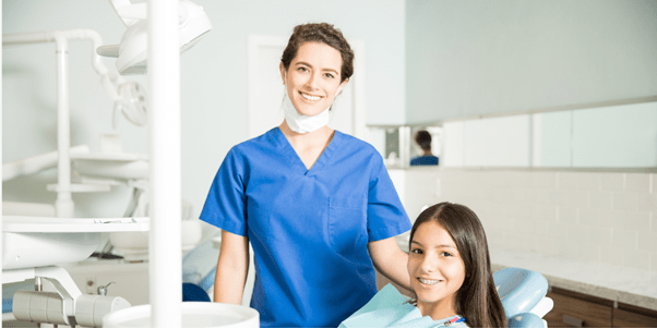 A smiling dentist with a smiling patient
