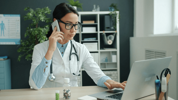 A lady doctor is holding her phone and listening a call